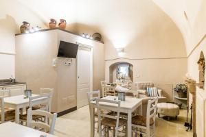 a dining room with tables and chairs and a tv at Borgo San Gaetano in Bernalda