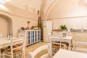 a kitchen with a table and chairs and a refrigerator at Borgo San Gaetano in Bernalda