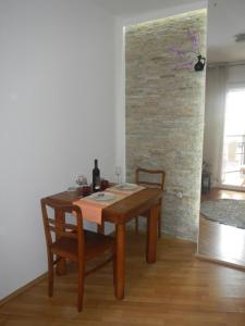 uma mesa de madeira e cadeiras num quarto com uma parede de tijolos em Apartment Boris em Niš