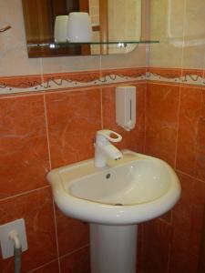 uma casa de banho com um lavatório branco e um espelho. em Apartment Boris em Niš