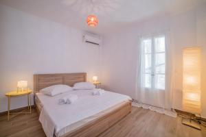 a white bedroom with a large bed with towels on it at Zante Deco Apartment in Zakynthos Town