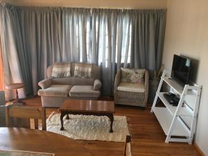 a living room with a couch and a table at Bridal Drift Cottage in Colenso