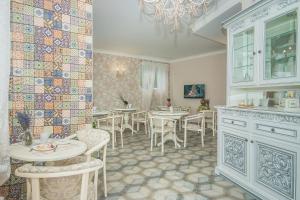 a dining room with tables and chairs and tiles on the wall at Mini Hotel Ryleev in Kharkiv