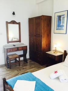 1 dormitorio con escritorio, 1 cama y espejo en Angeliki's Studios Paros, en Parikia