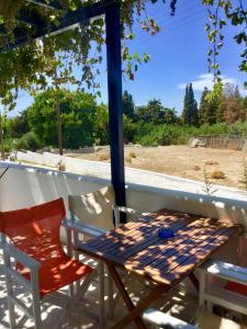 a table and chairs on a porch with a view of a field at Angeliki's Studios Paros in Parikia