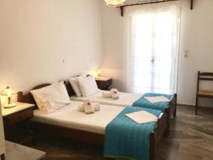a bedroom with two beds with towels and a window at Angeliki's Studios Paros in Parikia