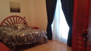 a bedroom with a bed and a window at Beach Hotel in Diamante