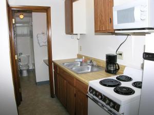 a small kitchen with a stove and a sink at Neptune Motel Maine in Old Orchard Beach