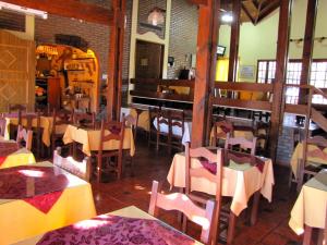 um restaurante com mesas e cadeiras num quarto em Hotel Altos del Rincon em Merlo