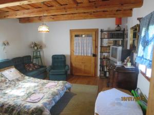 a bedroom with a bed and a couch and a tv at Molnárporta in Szentgyörgyvölgy
