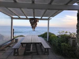 una mesa de picnic con el océano en el fondo en The Beach House - Glentana, en Glentana