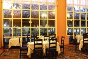 een eetkamer met tafels en stoelen en grote ramen bij Hesperia Isla Margarita in La Playa
