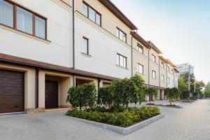 um edifício com uma fila de árvores à frente em Arcadia Villa Apartments em Odessa