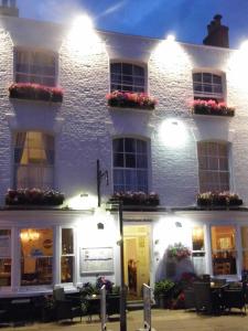 a white building with flowers on the windows and lights at Waterfront Hotel in Deal