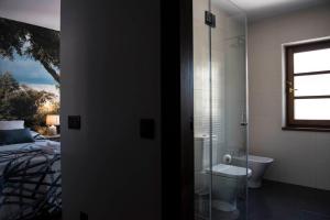 a bathroom with a shower and a toilet and a bed at Dos Aguas Arribes in Fermoselle