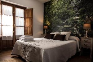 ein Schlafzimmer mit einem Bett mit einem großen Gemälde an der Wand in der Unterkunft Dos Aguas Arribes in Fermoselle