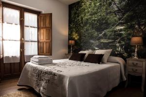 a bedroom with a bed with a large painting on the wall at Dos Aguas Arribes in Fermoselle