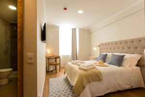 a bedroom with a large bed and a bathroom at Ericeira Soul Guesthouse in Ericeira +37 photos