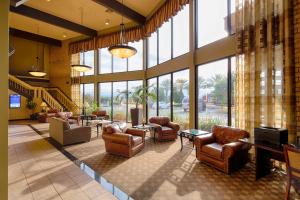 a lobby with leather chairs and tables and windows at Red Lion Hotel Redding in Redding +35 photos