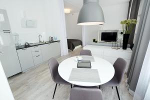 kuchnia i jadalnia z białym stołem i krzesłami w obiekcie Apartament Towarowa Kolobrzeg w Kołobrzegu
