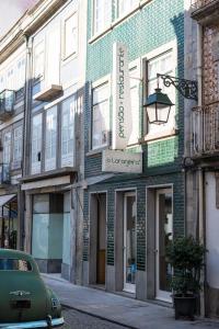 a building on a street with a car parked in front at Pensao O Laranjeira in Viana do Castelo