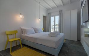 ポロニアにあるPollonia Sea View Apartmentsの白いベッドルーム(ベッド1台、黄色い椅子付)