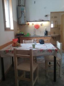 cocina con mesa con sillas y fregadero en Alojamiento Dell Acqua en Santa Rosa de Calamuchita