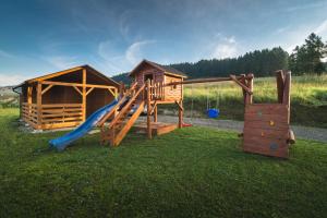 a playground with a slide and a play house at Domki Widokówka in Kluszkowce