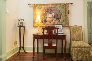 a desk with a chair and a painting on the wall at Daniel Stebbins B and B in South Hadley