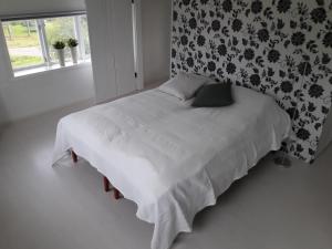 a bedroom with a bed with white sheets and a window at Orsastuguthyrning-Digerberget in Orsa