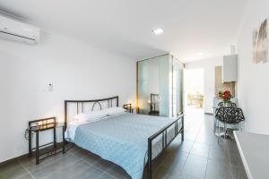 a bedroom with a large bed and a bathroom at Fexulis Studios & Suites in Agios Nikolaos