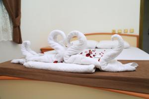 two towel swans sitting on top of a bed at Tunays Pansiyon in Cıralı +60 photos
