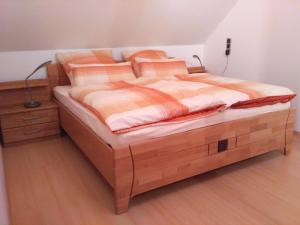 ガイレンキルヒェンにあるFerienwohnung Elina-Sophiaのベッドルーム1室(木製ベッド1台、木製ドレッサー付)
