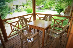 a wooden table and four chairs on a porch at Tunays Pansiyon in Cıralı