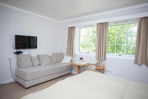 a white living room with a couch and a window at Stetind Hotel in Kjøpsvik