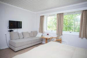 - un salon blanc avec un canapé et une fenêtre dans l'établissement Stetind Hotel, à Kjøpsvik
