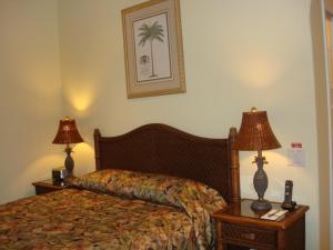 a bedroom with a bed and two night stands with lamps at Maui Beach House B & B in Kahana