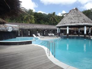 a resort swimming pool with a thatch roof at Stevensons at Manase in Manase