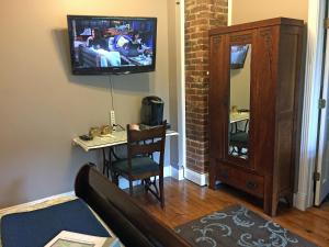 a living room with a couch and a tv on a wall at White Oak Manor Bed and Breakfast in Jefferson
