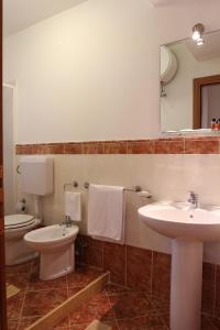 a bathroom with a sink and a toilet and a mirror at Residence Casa Del Mar Sicilia in Marina di Modica