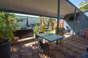 um pátio com uma mesa, cadeiras e plantas em Elkira Court Motel em Alice Springs