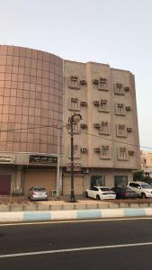 a large building with cars parked in front of it at منازل الساهر للوحدات السكنية فرع 1 in Al Qunfudhah