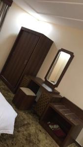 a room with a mirror and a table with a sink at منازل الساهر للوحدات السكنية فرع 1 in Al Qunfudhah