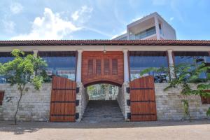 ein Haus mit Holztüren und Treppen vorne in der Unterkunft Triple O Six in Mirissa