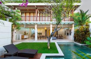 una casa con piscina y un árbol en el patio en Dream villa Seminyak, en Seminyak