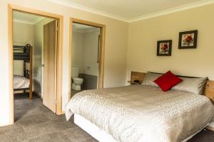 a bedroom with a bed with a red pillow at Sunny Gum in Penguin
