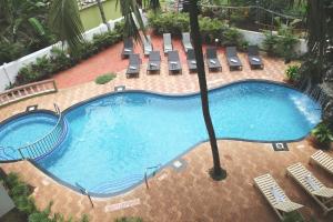 an overhead view of a large swimming pool with chairs at Silver Sands Sunshine - Angaara in Candolim