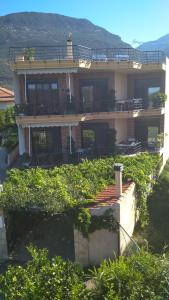 Una casa grande con muchos arbustos delante. en Nikolitsa Apartments, en Glyfada Fokidas