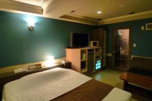 a bedroom with a bed and a green wall at Hotel GOLF III Atsugi (Adult Only) in Atsugi