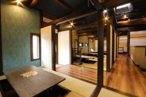 a room with a table and a piano in the distance at Minshuku Asogen in Aso